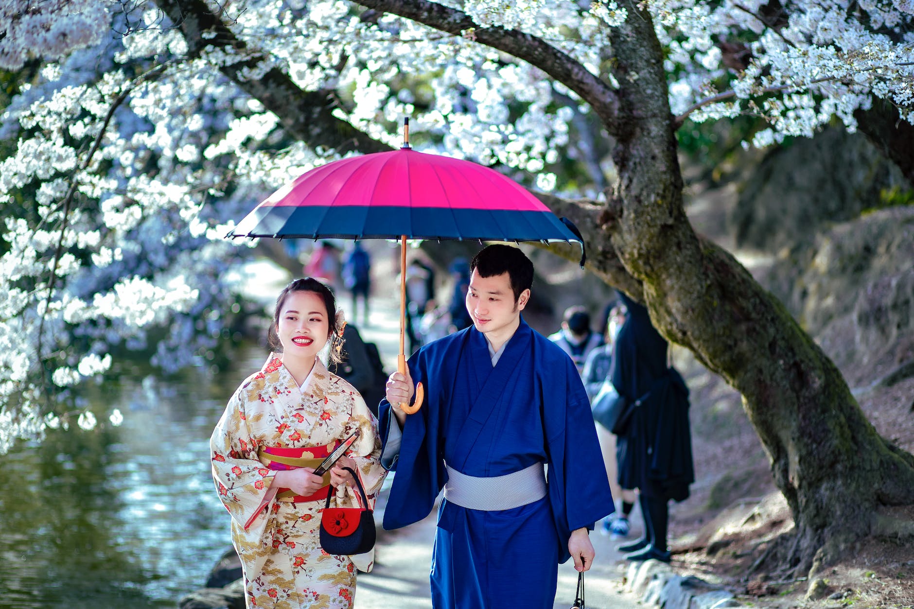 photo of a woman in a floral kimono walking with a man in blue clothes